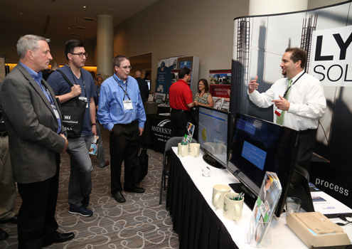 Symposium attendees at the Lydon Solutions booth