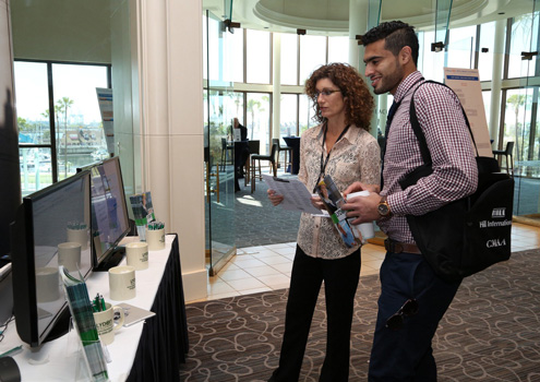 Melinda Michael, SharePoint coordinator at Lydon Solutions, chats with a symposium attendee
